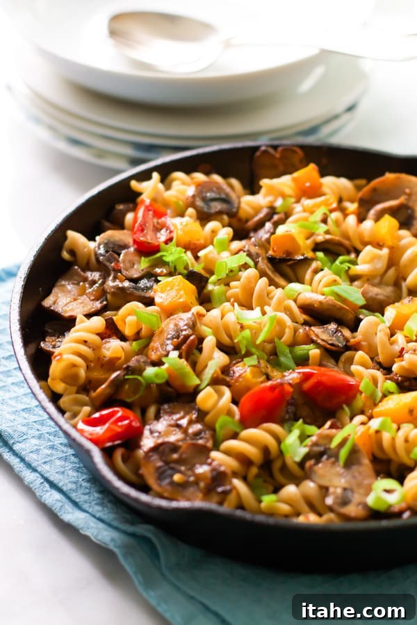 Fusilli with Mushroom and Roasted Butternut Squash A generous serving of Fusilli with Mushroom and Roasted Butternut Squash in a rustic cast iron pan, ready to be enjoyed.