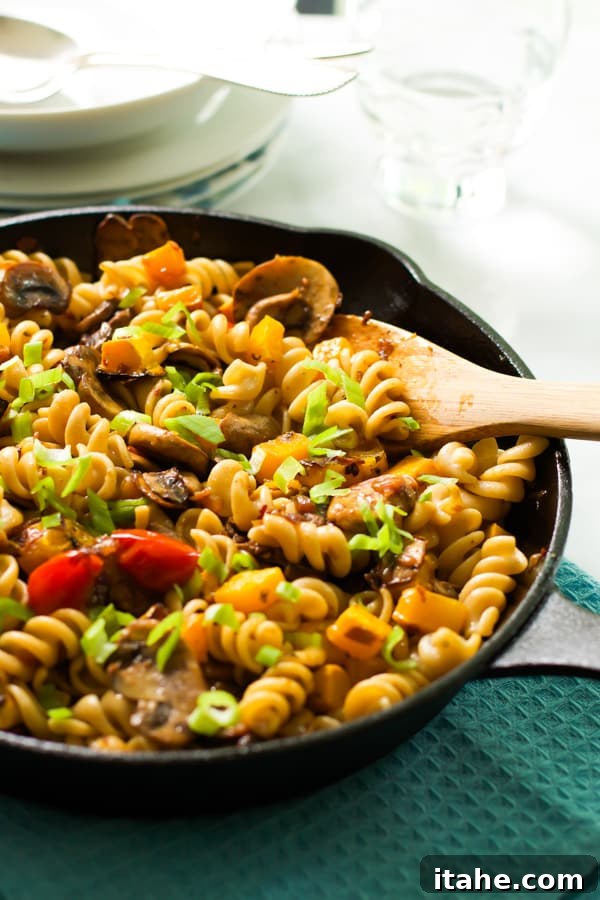 Fusilli with Mushroom and Roasted Butternut Squash Close-up of a spoon scooping Fusilli with Mushroom and Roasted Butternut Squash from a bowl, highlighting the texture and rich colors.