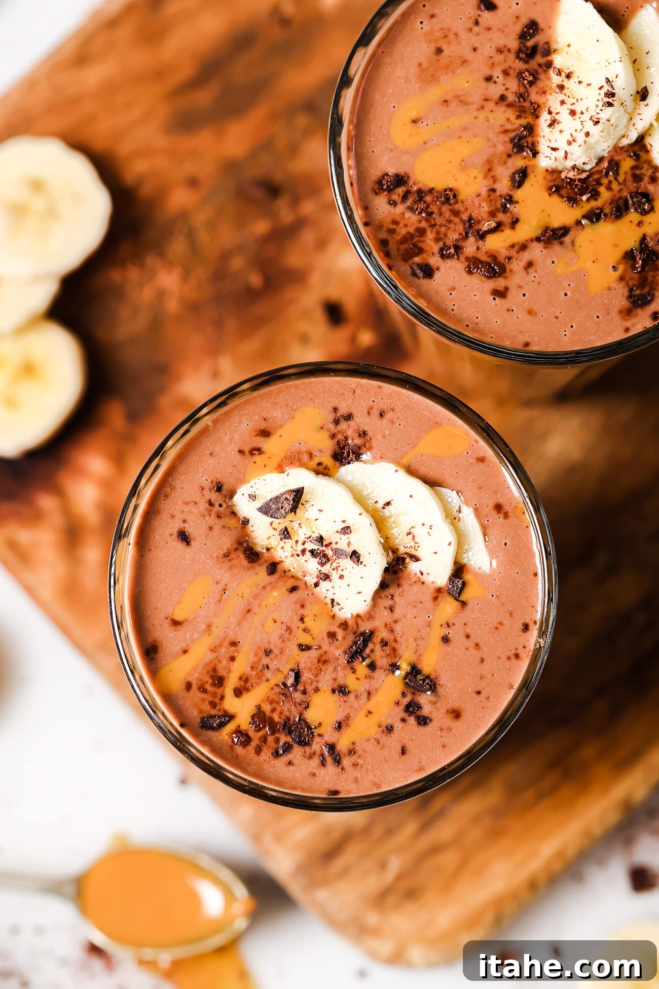 An overhead view of a delicious peanut butter chocolate smoothie garnished with banana slices, ready to be enjoyed.