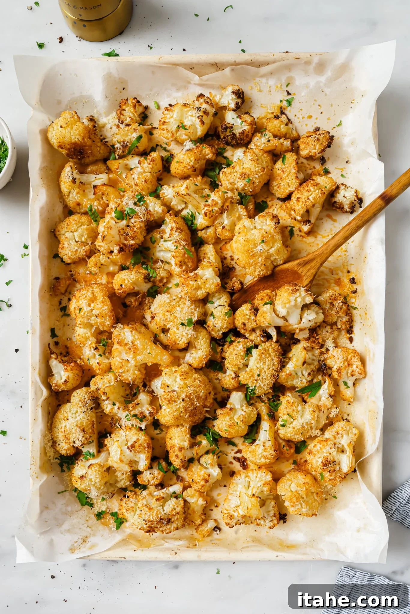 Golden Garlic Parmesan Roasted Cauliflower 7 Close up of roasted cauliflower with parsley as garnish, showing the golden-brown edges and appealing texture.