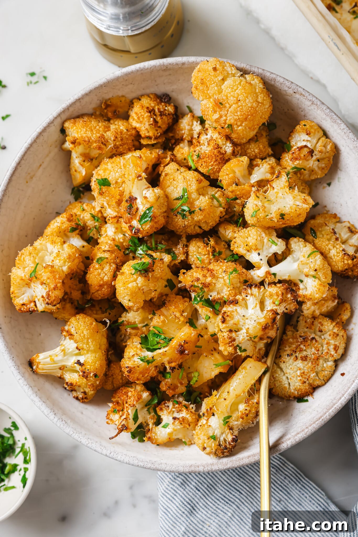 Golden Garlic Parmesan Roasted Cauliflower 8 Close up of roasted cauliflower with parsley as garnish, showcasing the rich golden color and appealing texture of the cooked florets.