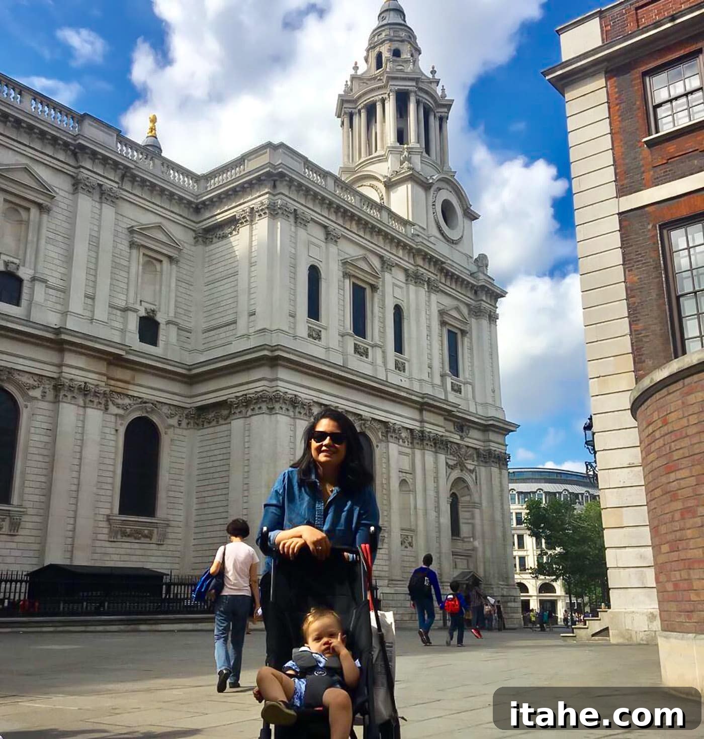 A mother pushing her toddler in a stroller on a London street