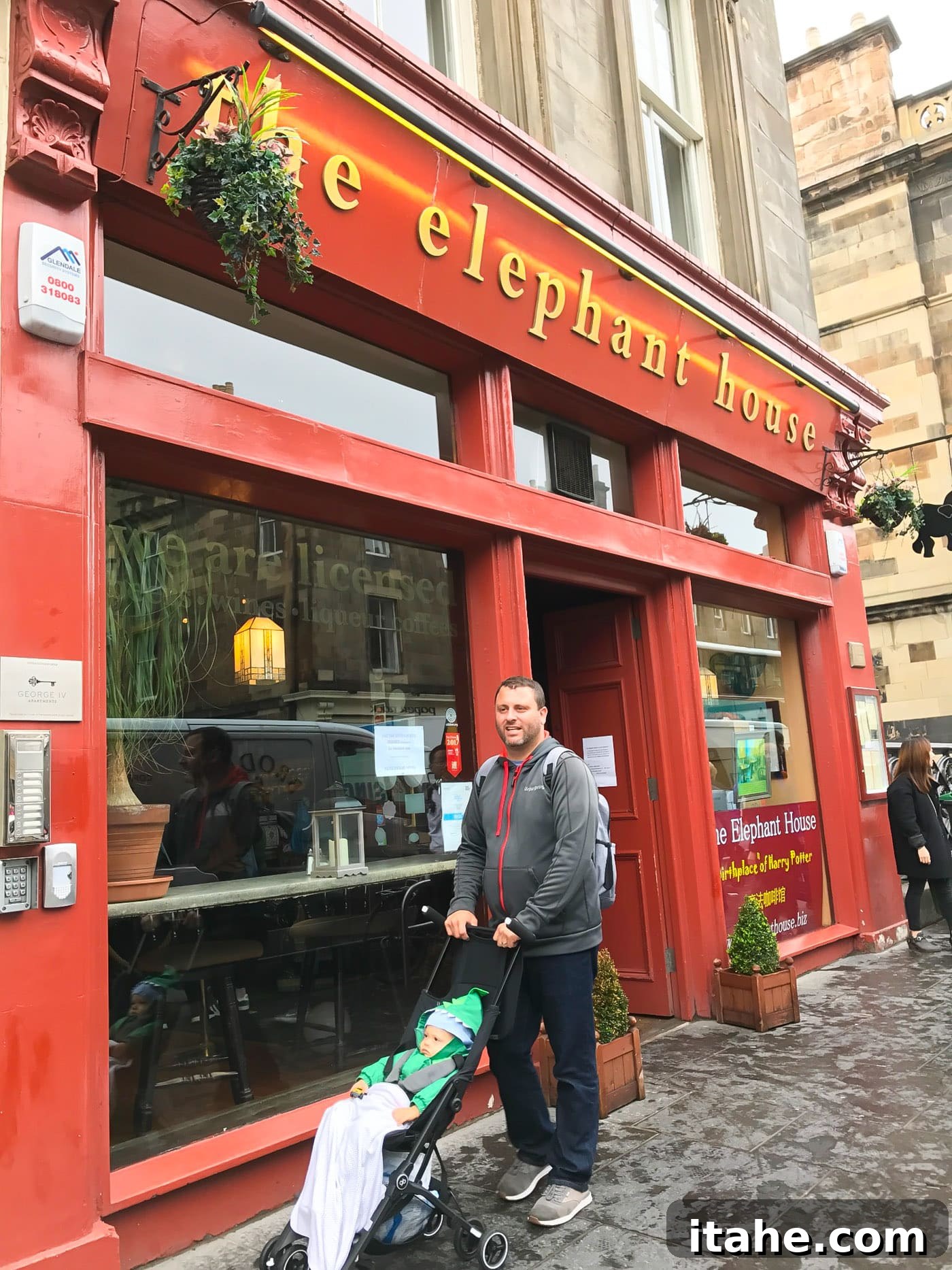 A father and toddler strolling along a scenic Edinburgh street with historic buildings