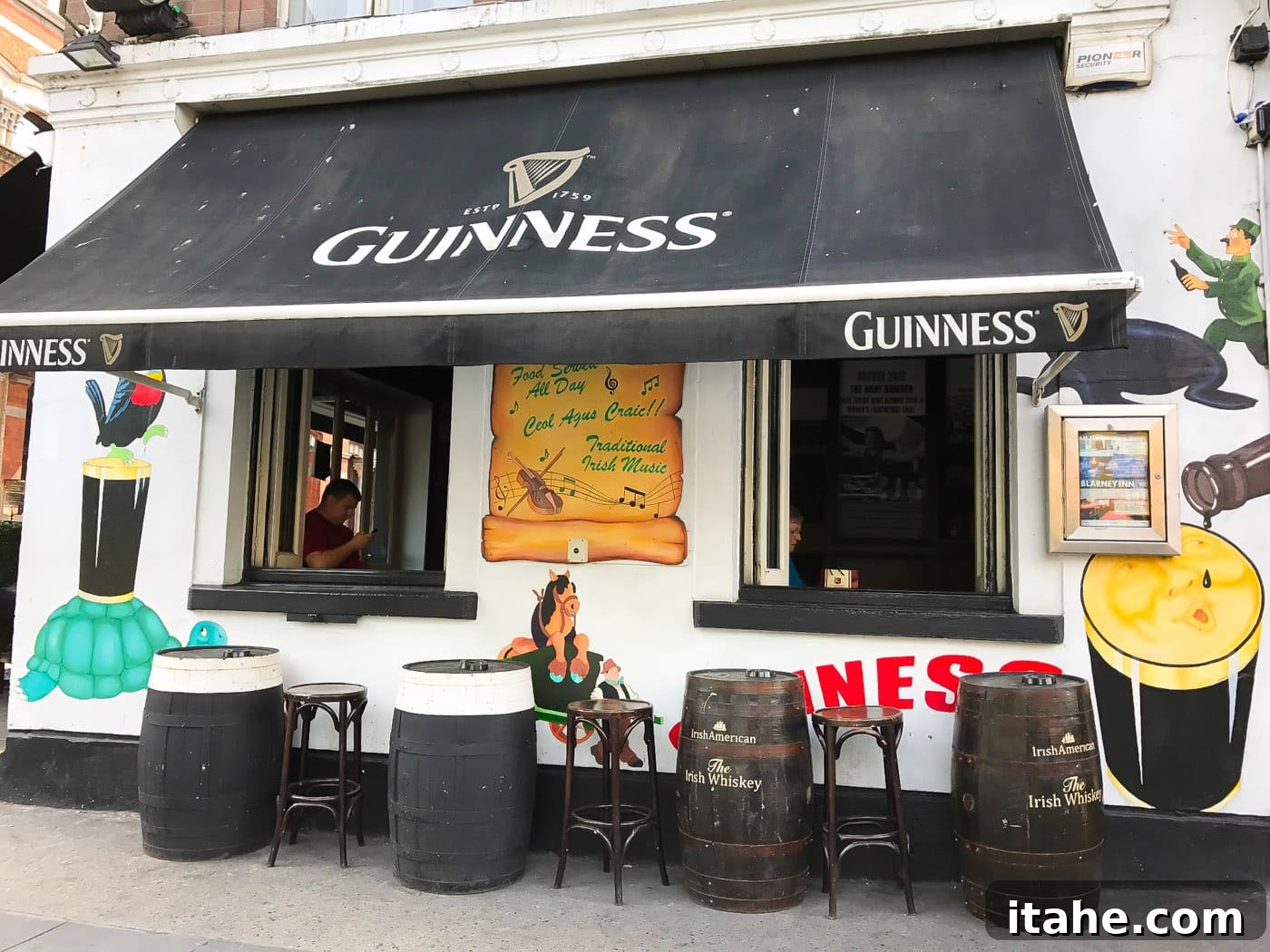 A cheerful outdoor pub setting in Dublin with beer kegs as tables