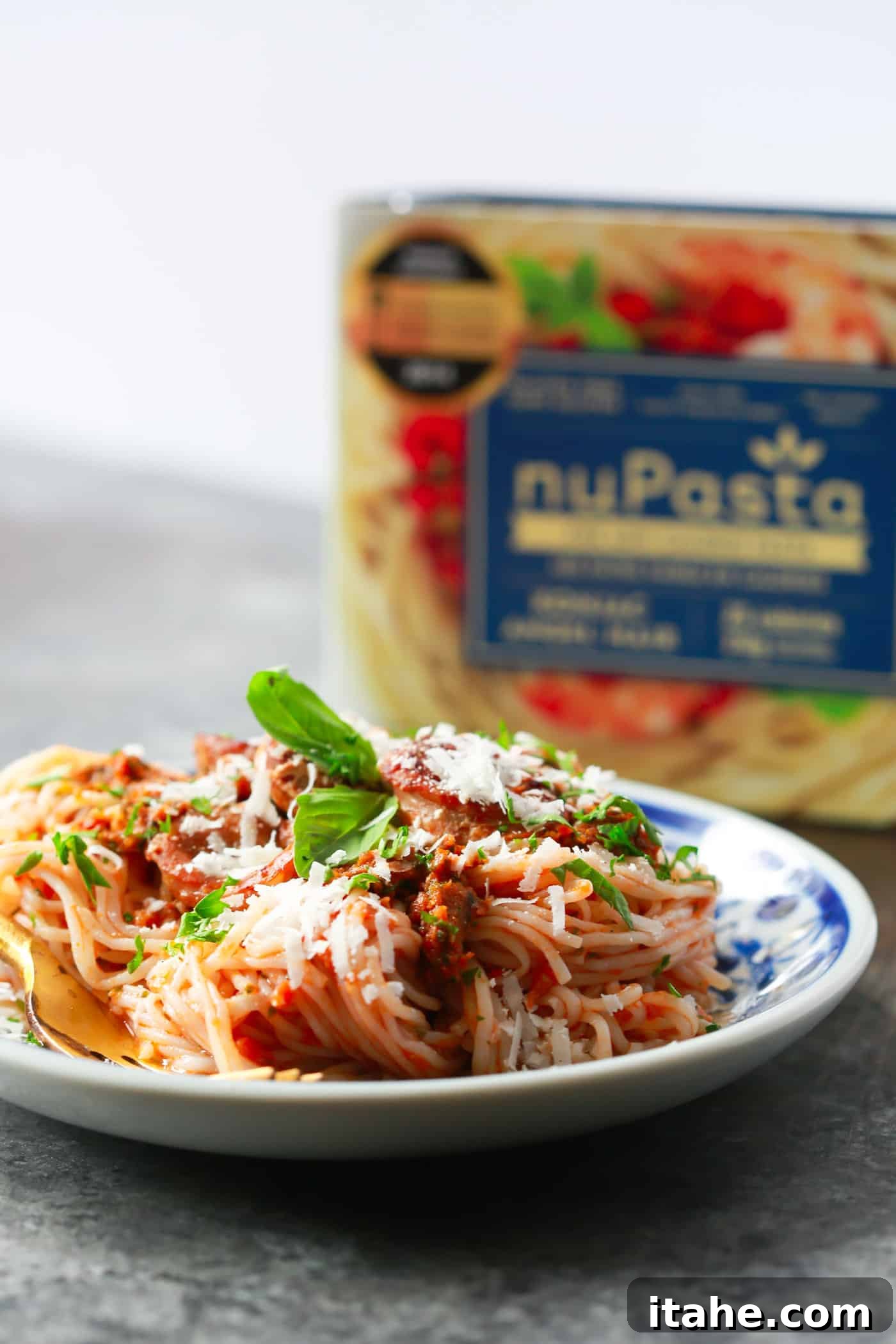 Savoring Low-Carb Italian Pesto Pasta Close-up of fork twirling Italian Sausage Sun-dried Tomato Pesto Pasta, showcasing the rich sauce and tender sausage