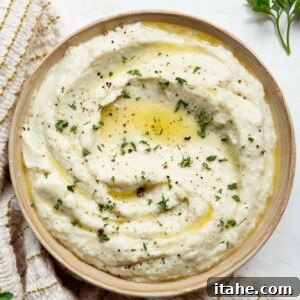 A high-angle shot of a bowl of creamy mashed cauliflower, ready to be served.