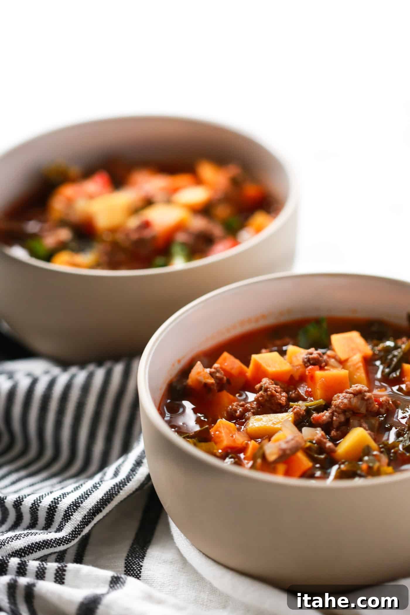 Ground Beef Butternut Squash Kale Soup served in a rustic bowl with a spoon