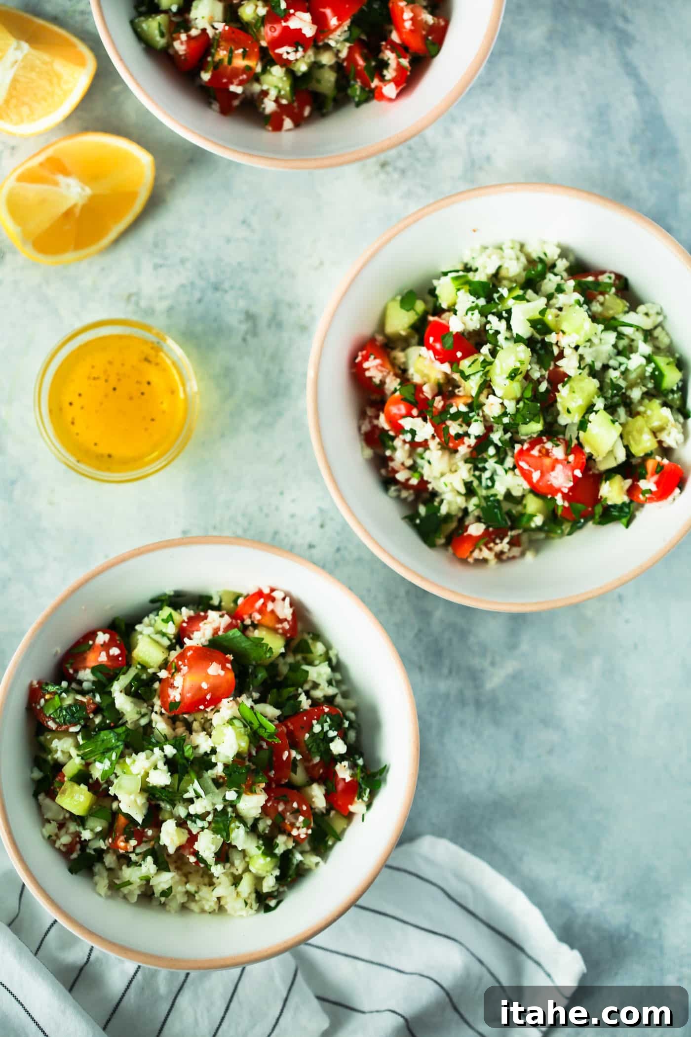 Overhead view of two aesthetically pleasing bowls brimming with healthy and fresh cauliflower rice tabbouleh salad, garnished for presentation.