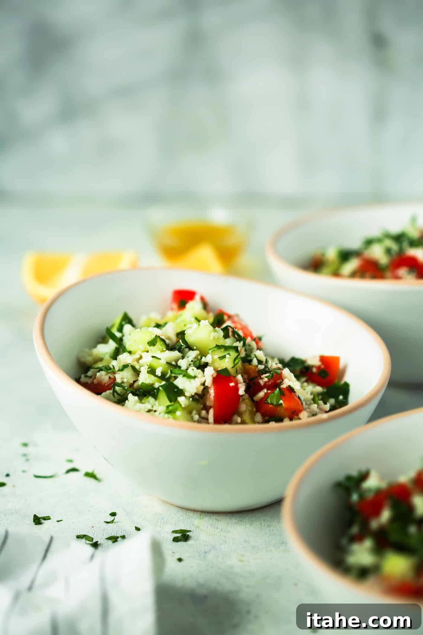 Close-up shot of a single bowl of Cauliflower Rice Tabbouleh Salad, highlighting the fresh, chopped vegetables and delicate texture of the cauliflower rice.