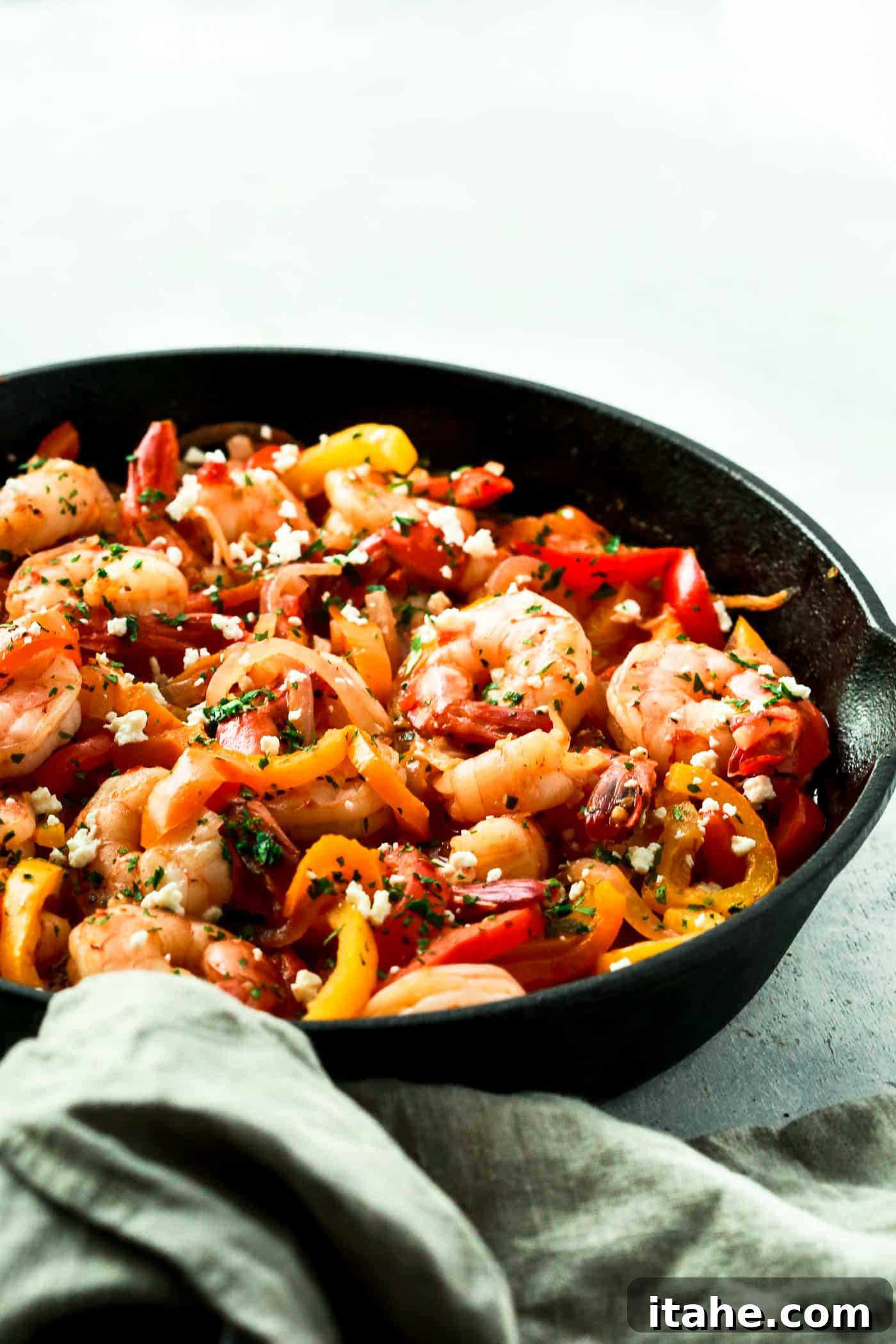 Shrimp, Bell Pepper and Onions Skillet plated with fresh herbs