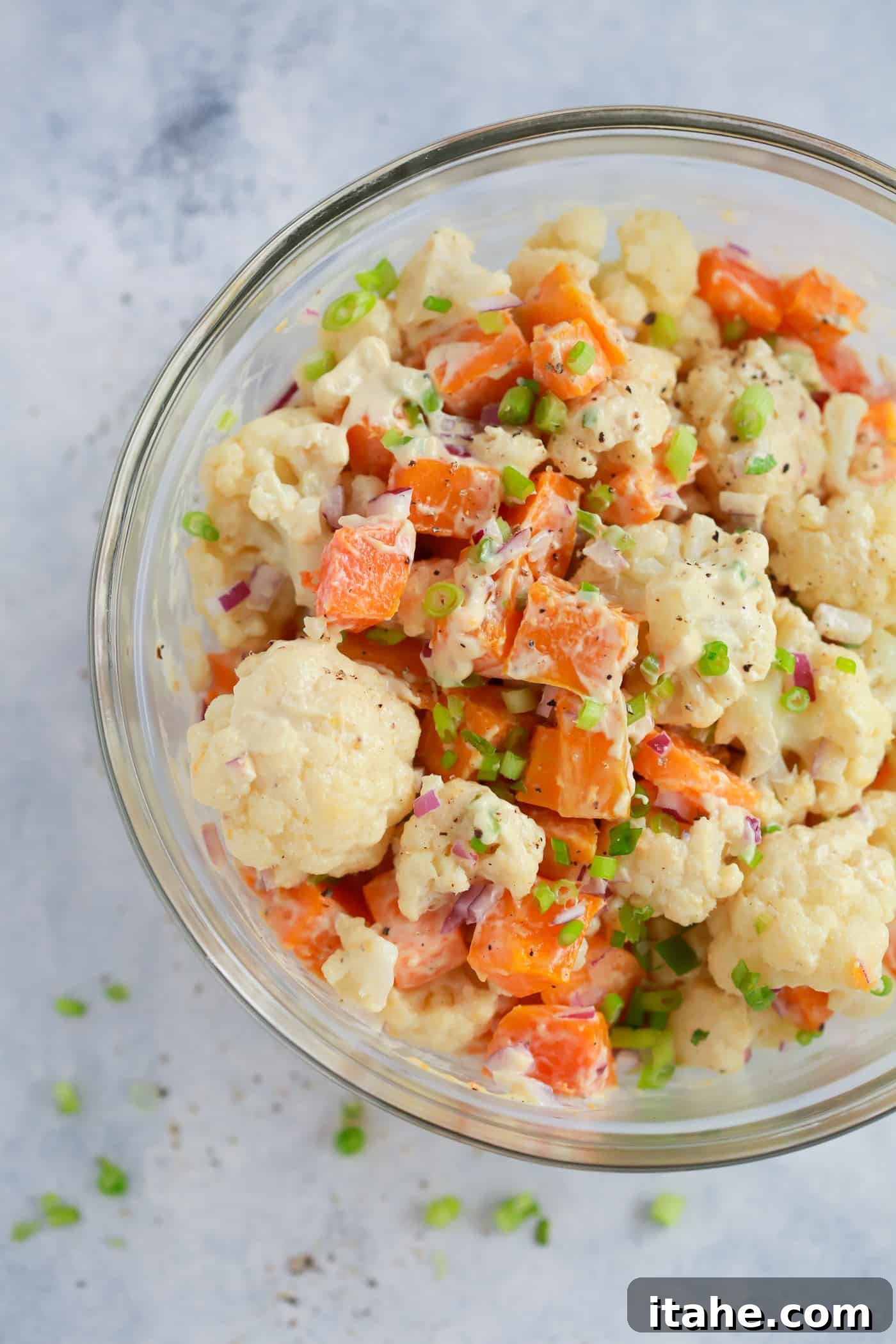 Fresh & Filling Low-Carb Lunches 12 Overhead view of roasted butternut squash and cauliflower salad in a clear glass bowl.