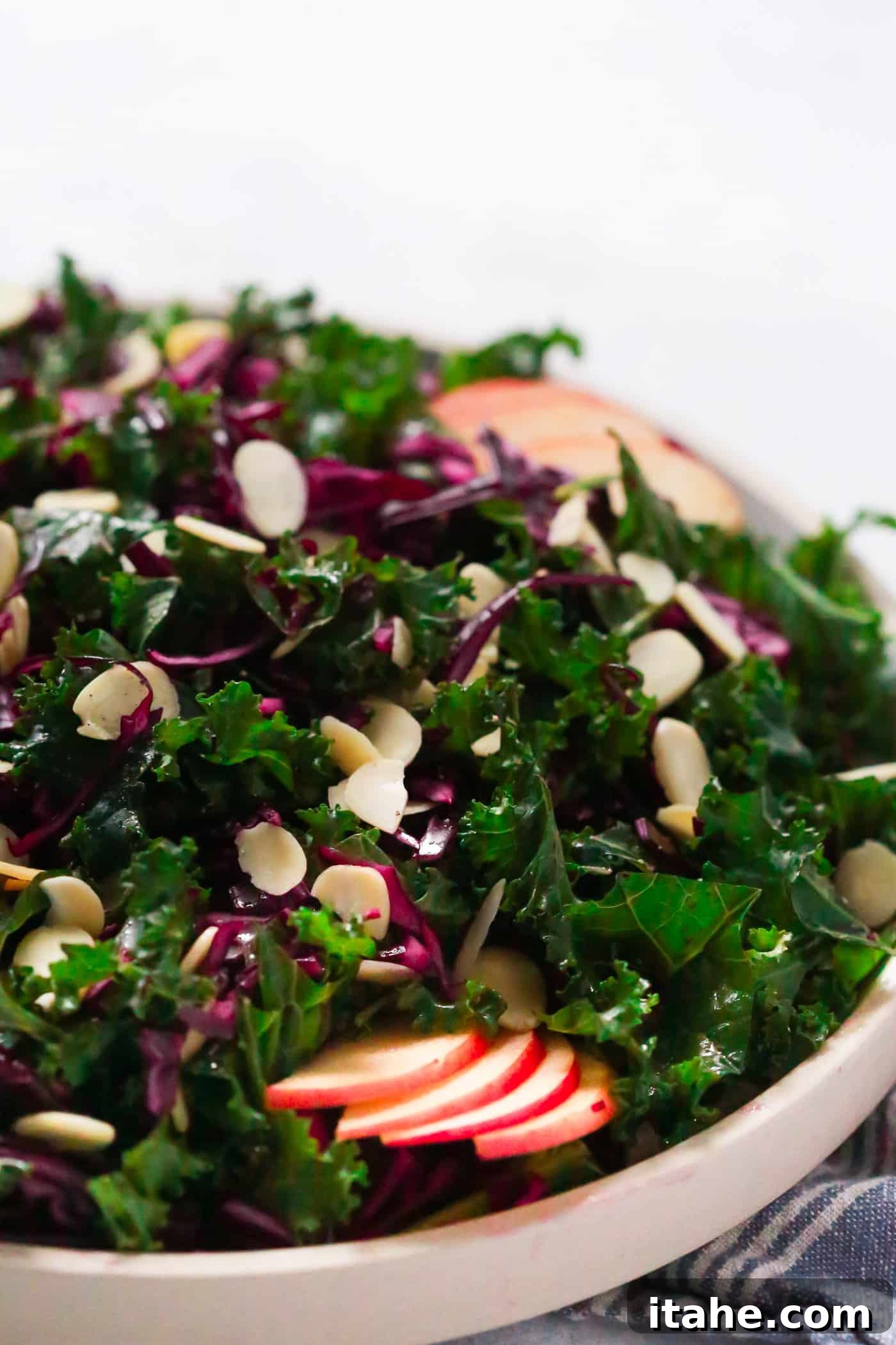 Fresh & Filling Low-Carb Lunches 16 Close-up view of a vibrant Chopped Red Cabbage Kale Salad in a grey bowl, highlighting the colorful ingredients.
