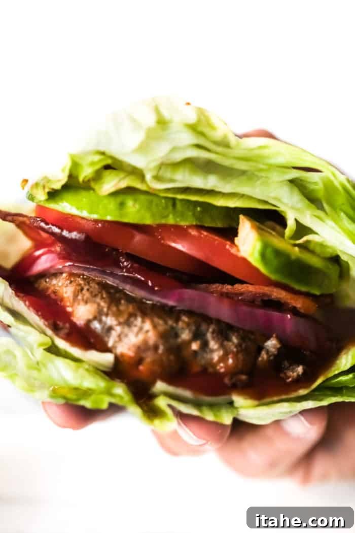 Delicious Bunless Burger Ideas 4 showing a hand holding a bunless burger, ready to be enjoyed.