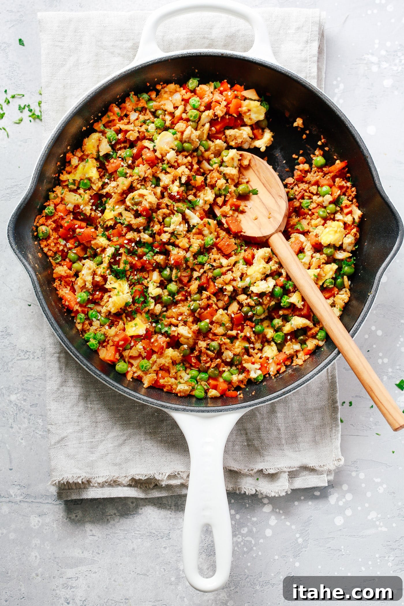 A close-up of a cast iron skillet showcasing beautifully cooked fried cauliflower rice, an excellent low-carb alternative.