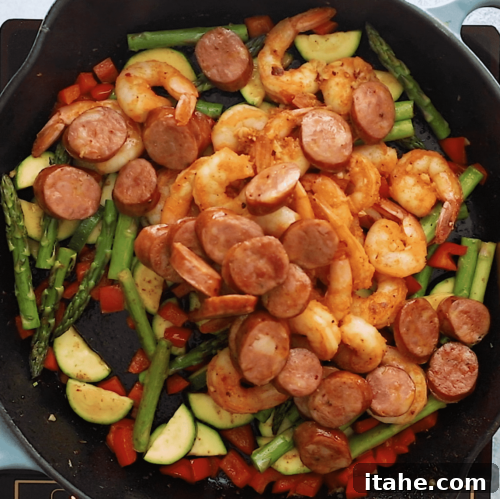 overhead view of a cast iron skillet containing finished shrimp and sausage skillet with vegetables