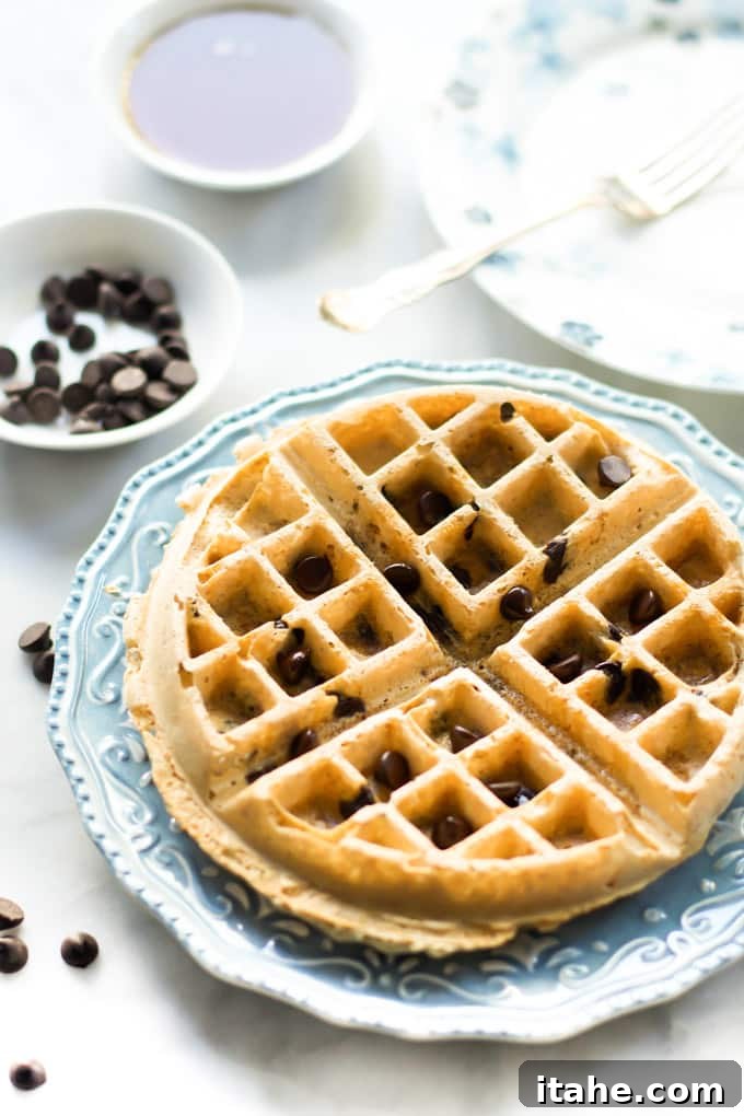 A beautifully presented plate of almond butter waffles, stacked and ready for toppings.