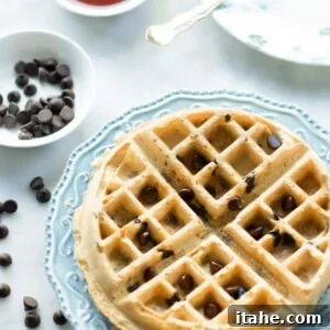 Close-up of a perfectly cooked almond butter waffle on a plate.