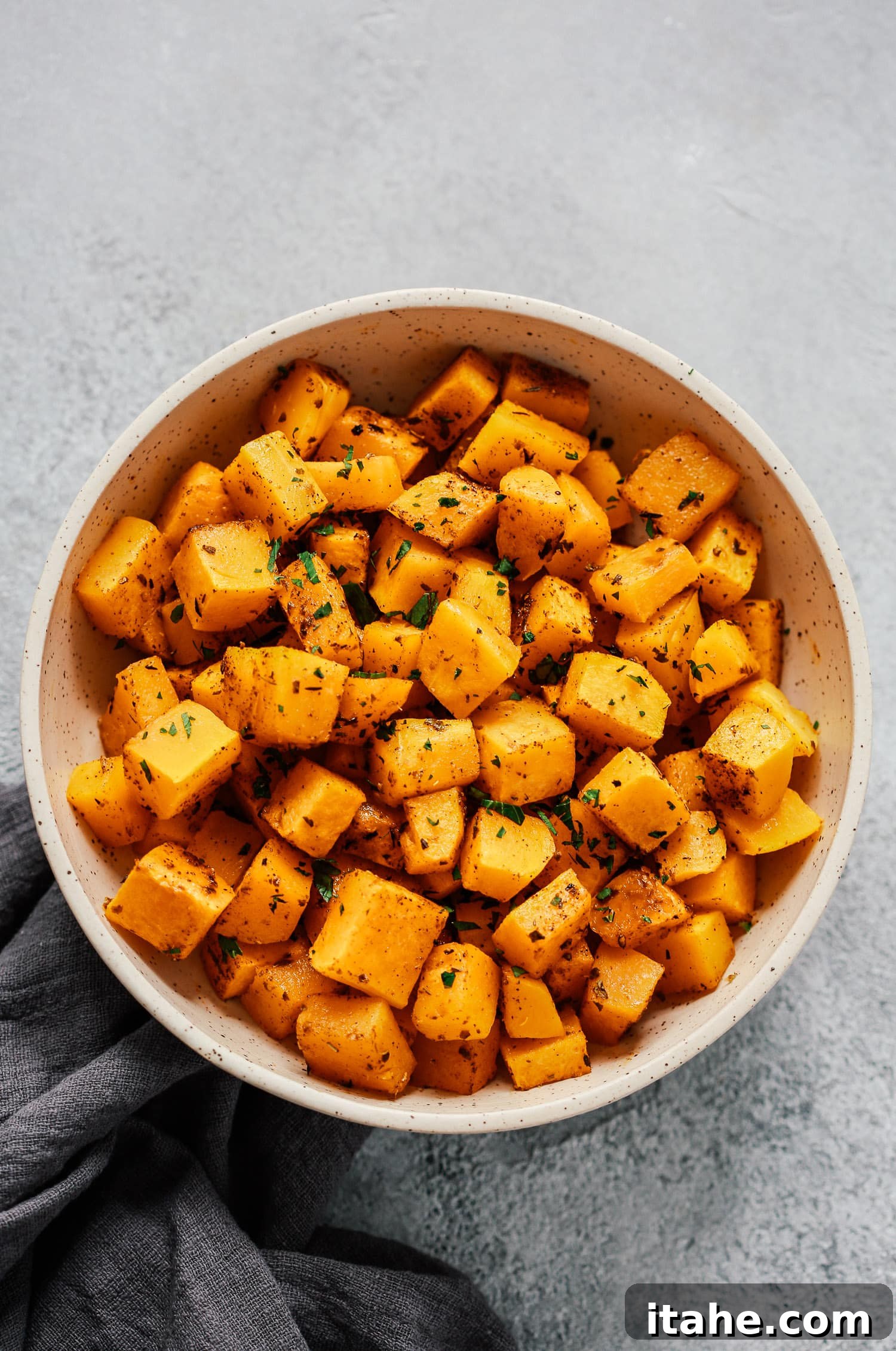 Overhead photo of a white bowl of roasted butternut squash.