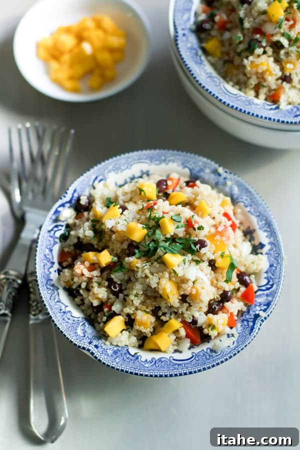 Mango Quinoa Salad Mango Quinoa Salad Primavera Kitchen Recipe - A bowl of fresh mango quinoa salad, garnished with parsley.