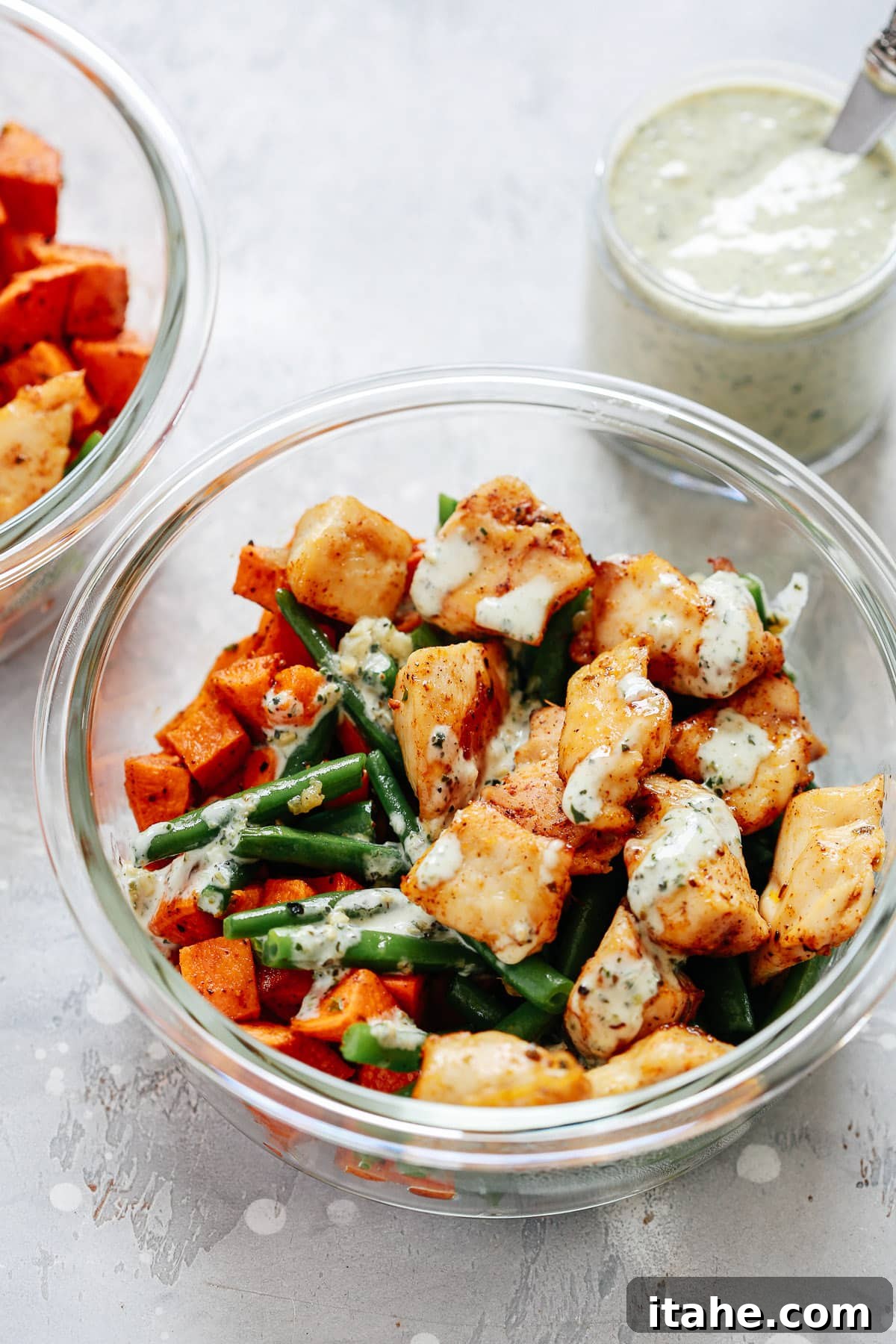 chicken and vegetables in creamy pesto sauce in meal prep recipe container