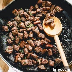 steak bites cooking in a skillet
