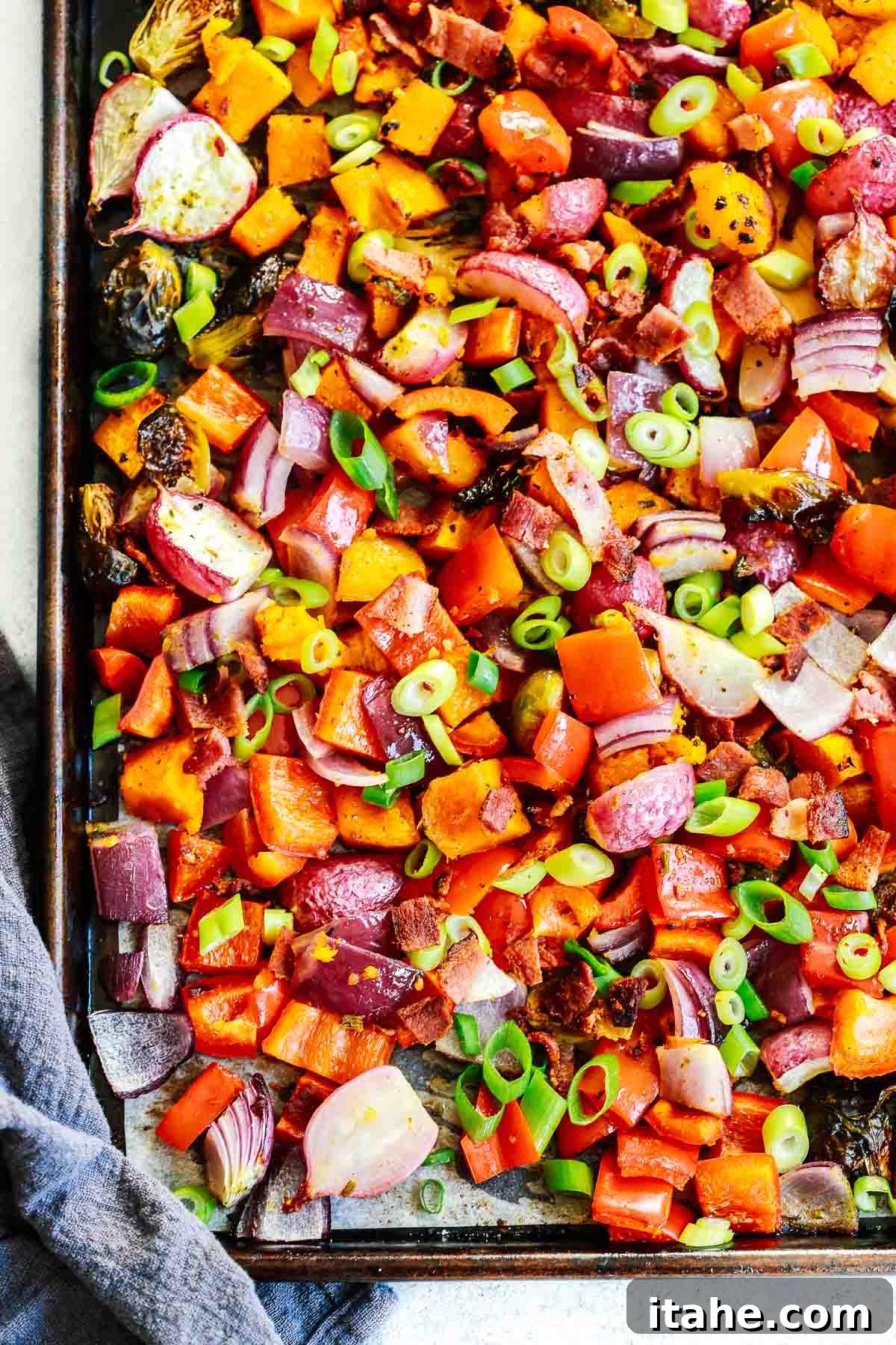 Overhead photo of a sheet pan with a fresh batch of healthy roasted vegetables, showcasing their vibrant colors and crispy textures.