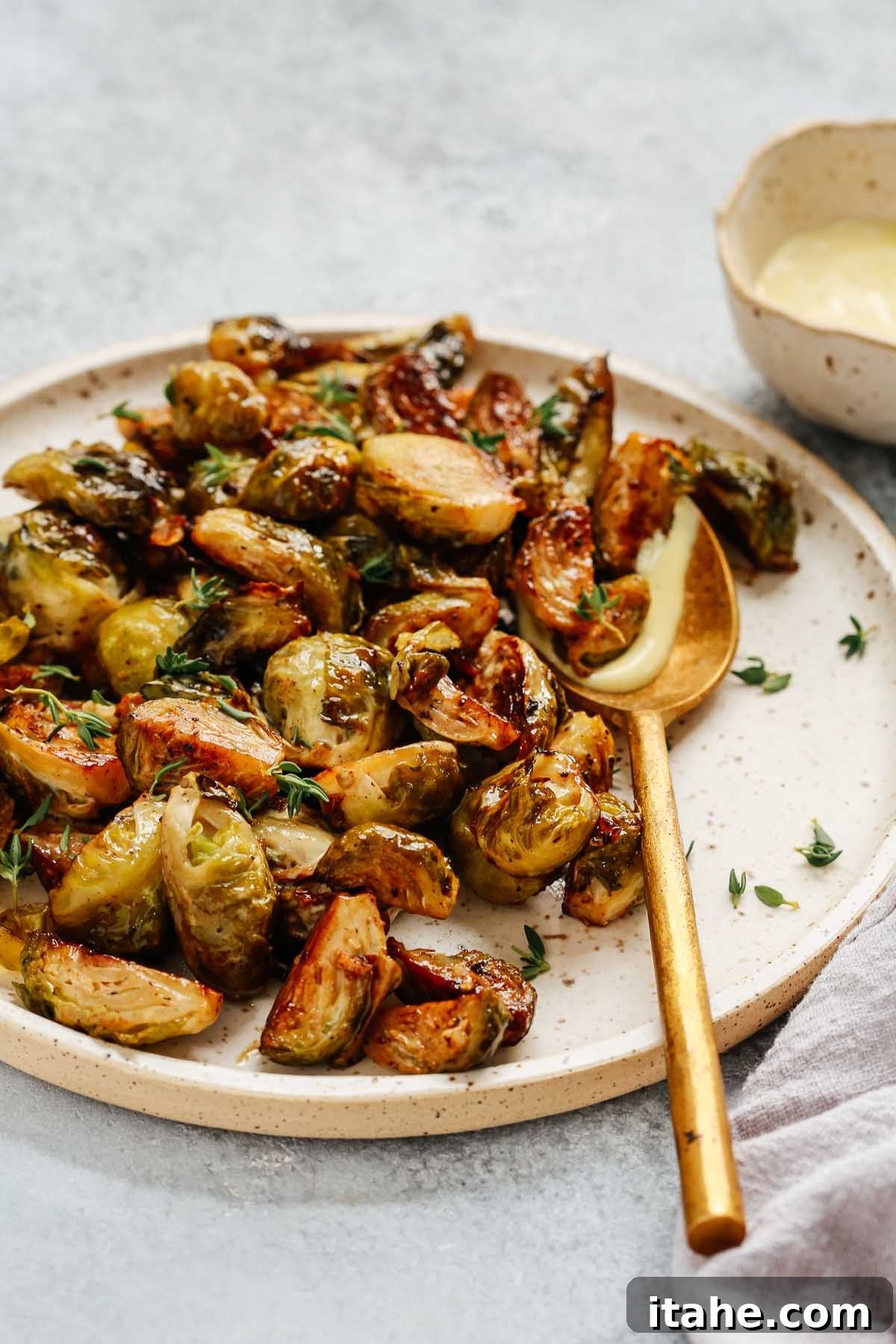 Close-up photo of a vibrant platter of golden-brown roasted Brussels sprouts, perfectly caramelized and seasoned.