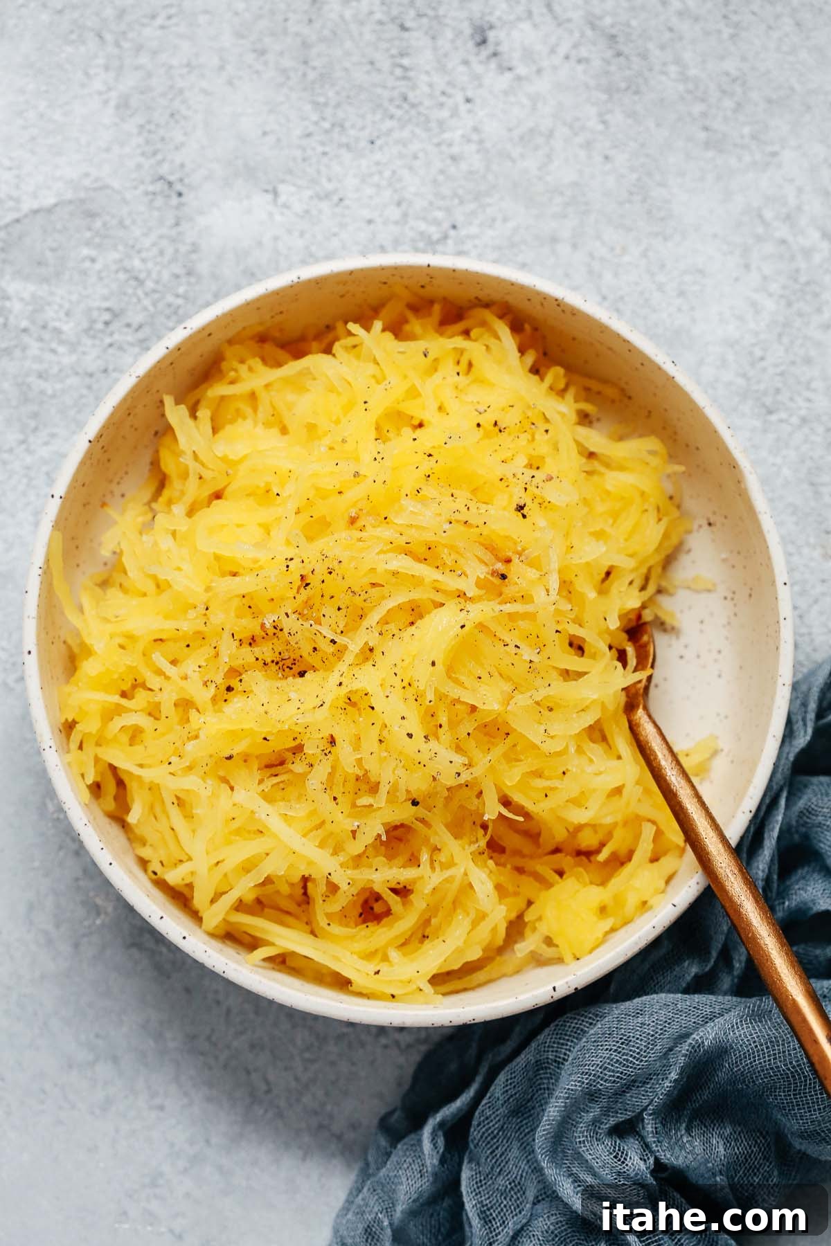 How to Roast Spaghetti Squash – A beautifully roasted spaghetti squash cut in half, showcasing its golden strands ready to be scraped.
