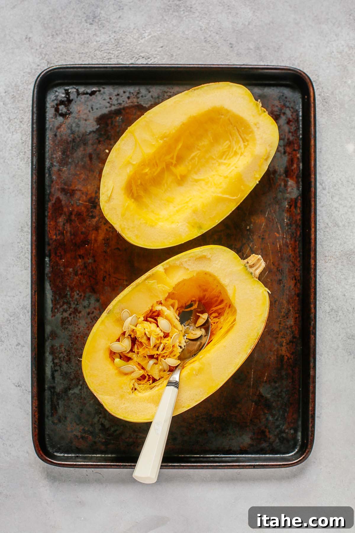 Spaghetti squash halves with seeds and stringy bits removed, ready for seasoning.