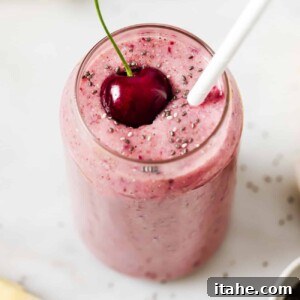a glass of cherry smoothie on a countertop