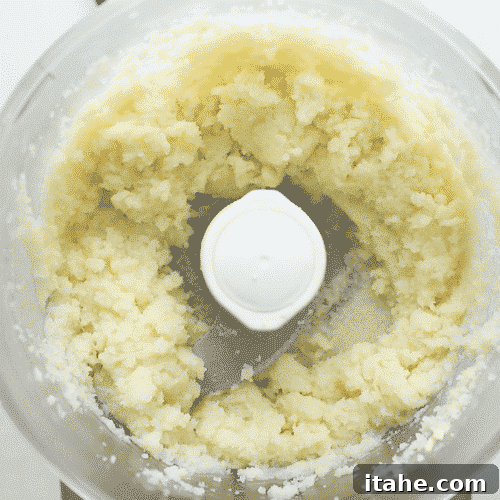 overhead view of a food processor containing cauliflower