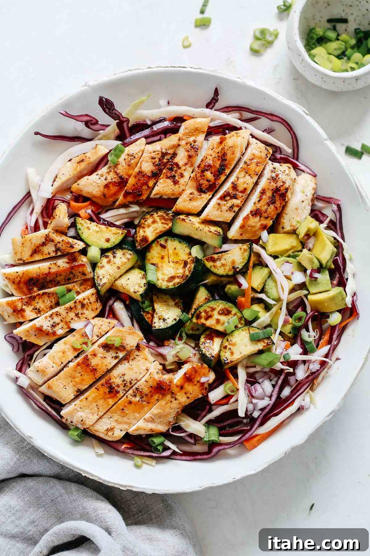 Overhead shot of vibrant chicken cabbage salad with grilled chicken, fresh vegetables, and a light dressing.