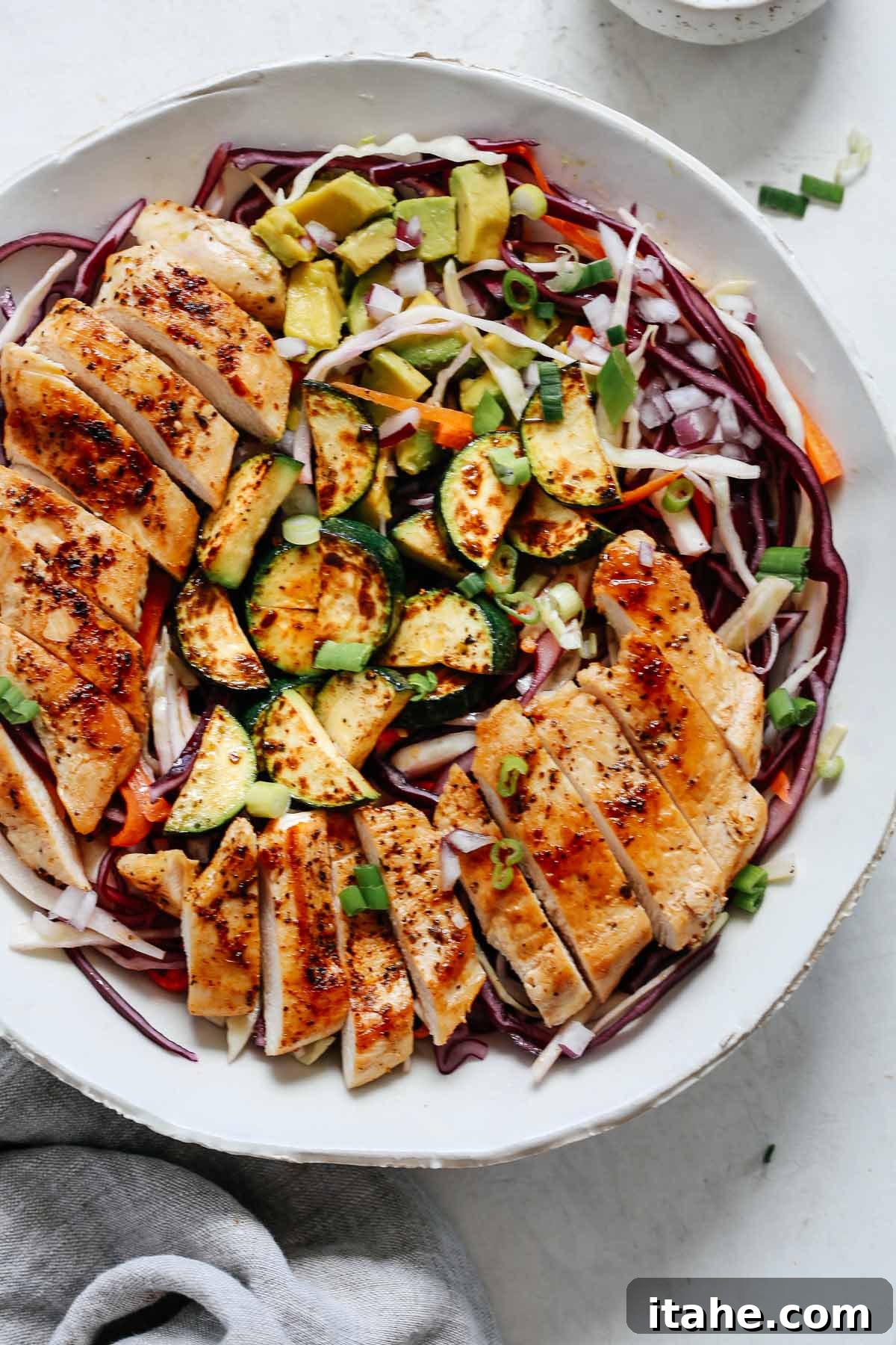 A vibrant closeup of chicken cabbage salad in a bowl, showcasing the crisp textures and colorful ingredients.