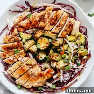 Overhead shot of cabbage salad with grilled chicken.