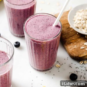 A close-up view of a refreshing blueberry banana smoothie, presented in a clear glass, garnished with fresh blueberries, exuding vibrancy and health.
