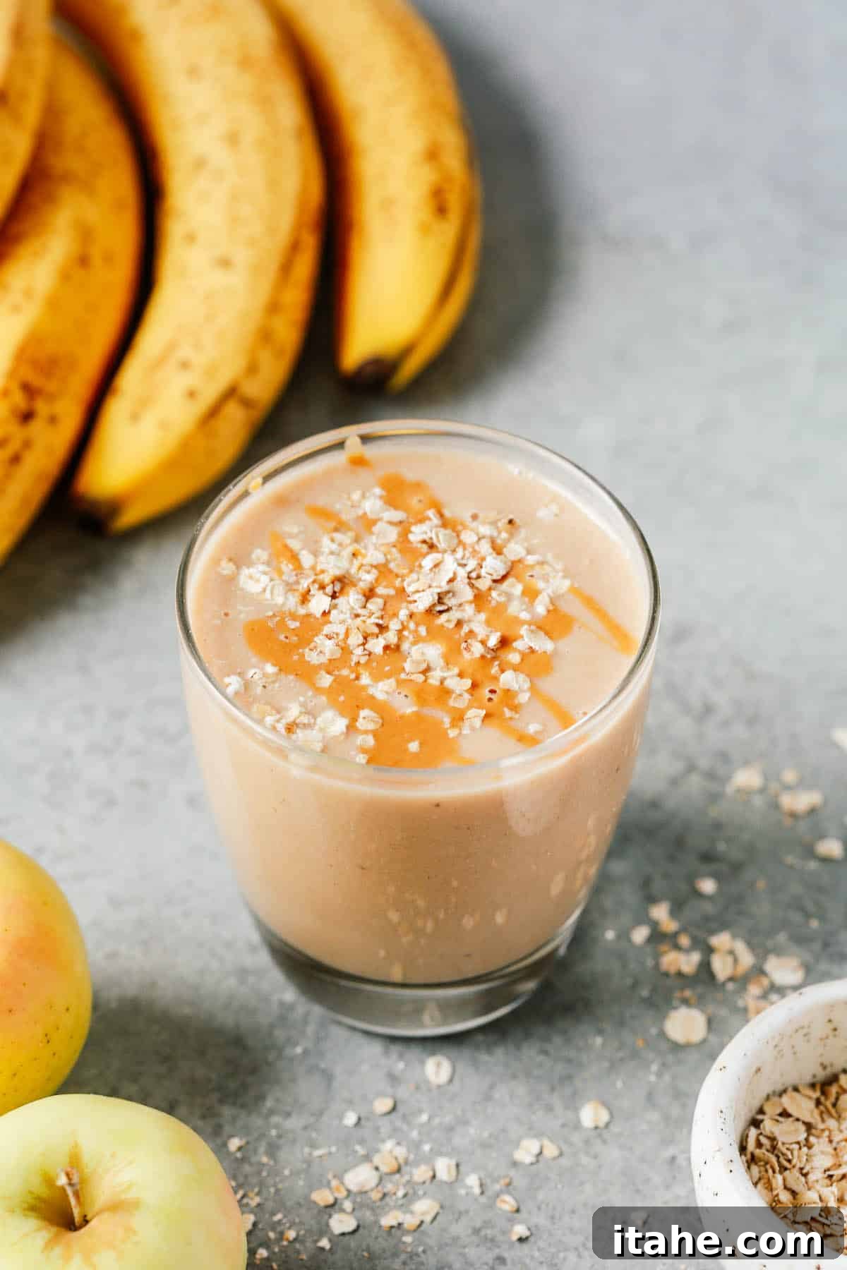 Crisp Apple Blend 2 A vibrant cup of creamy apple smoothie, garnished with a sprinkle of oats, ready to be enjoyed for breakfast or as a healthy snack. It's dairy-free, gluten-free, and vegan-friendly.