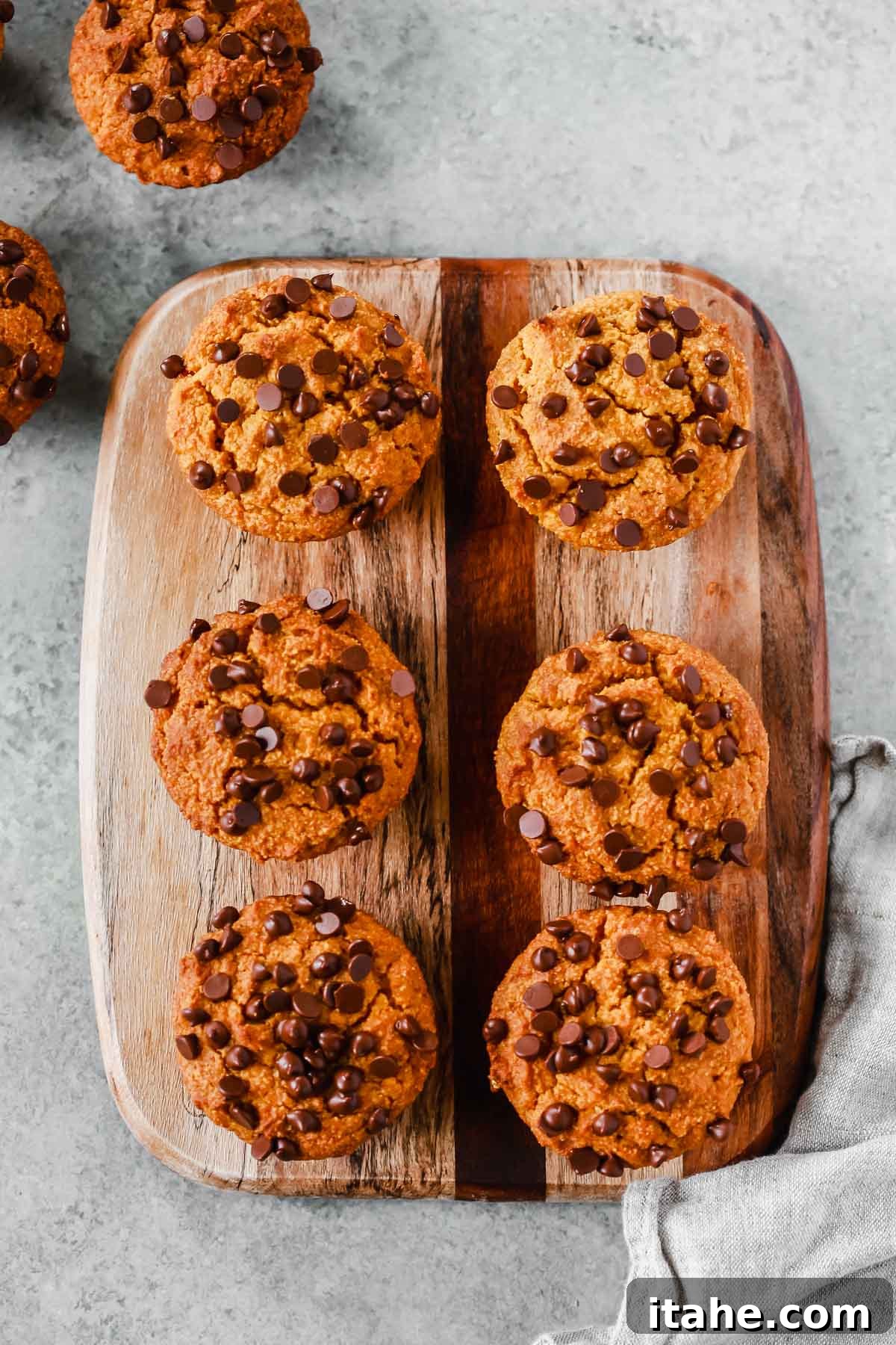 Six healthy pumpkin chocolate chip muffins arranged beautifully on a serving board, ready to be enjoyed.