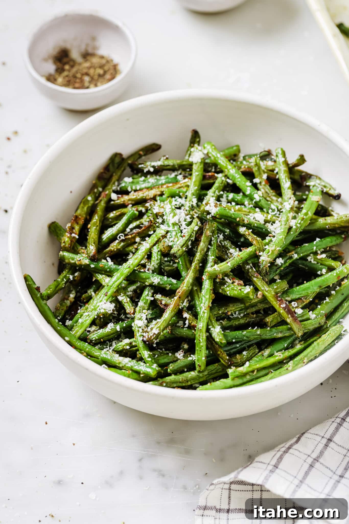 Close up of a bowl of parmesan green beans, garnished and ready to serve.