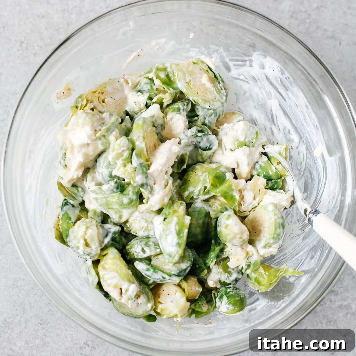 Creamy Brussels Sprouts Gratin 4 Brussels sprouts with cheese mixture in a glass bowl.