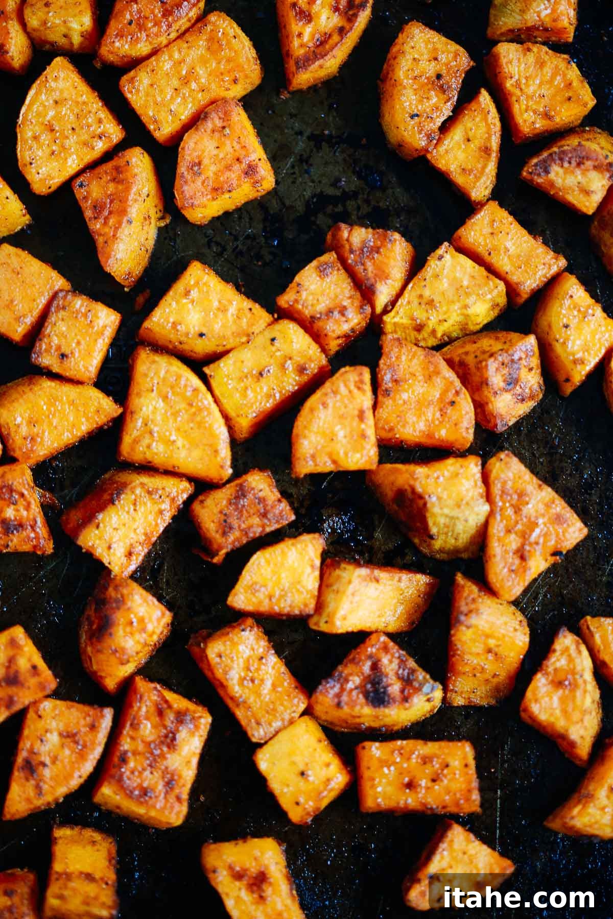 Caramelized Sweet Potato Delight 3 close up of perfectly golden roasted sweet potato on a baking tray, showing crispy edges