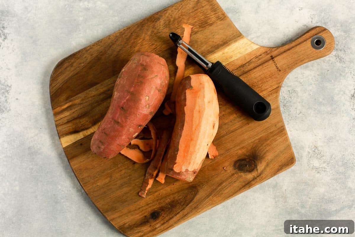 Caramelized Sweet Potato Delight 4 partially peeled sweet potato on a wooden cutting board, ready for dicing