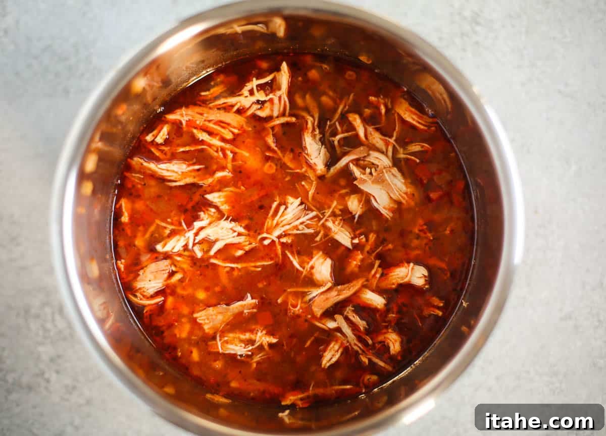 Instant Pot Fiesta Chicken Soup 5 A close-up shot of the Instant Pot liner, now containing the perfectly cooked Southwest Chicken Soup with tender shredded chicken.