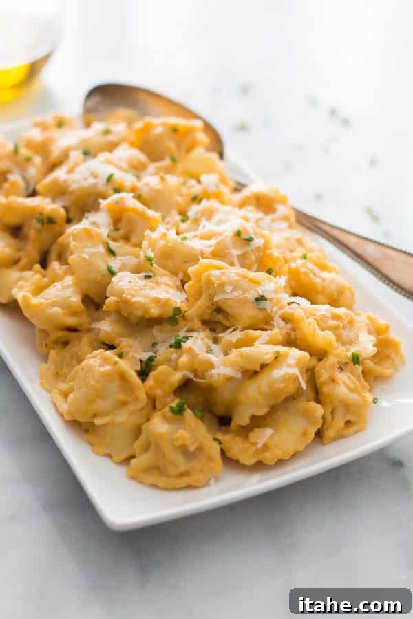 A platter of tortellini pumpkin sauce with a spoon, garnished with fresh parsley.