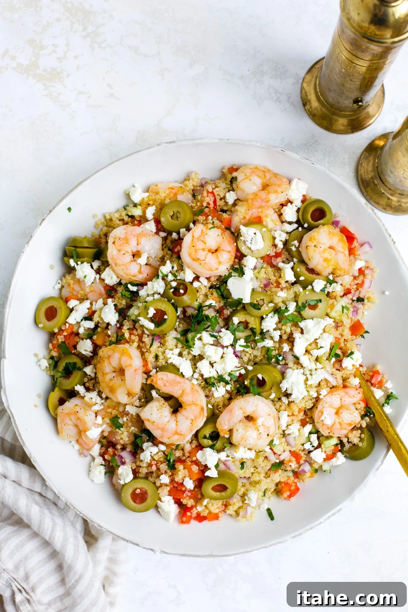 Overhead view of a white bowl of shrimp quinoa.