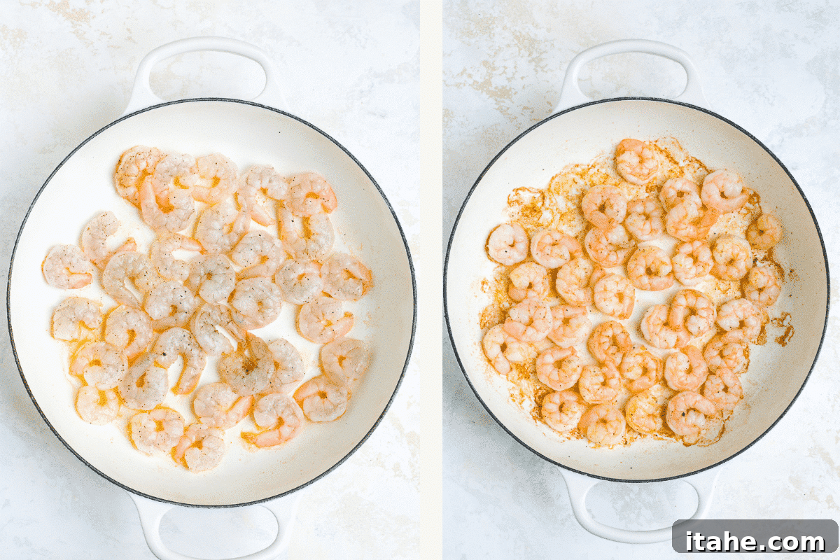 Overhead view of cooked shrimp in a white cast-iron braising skillet