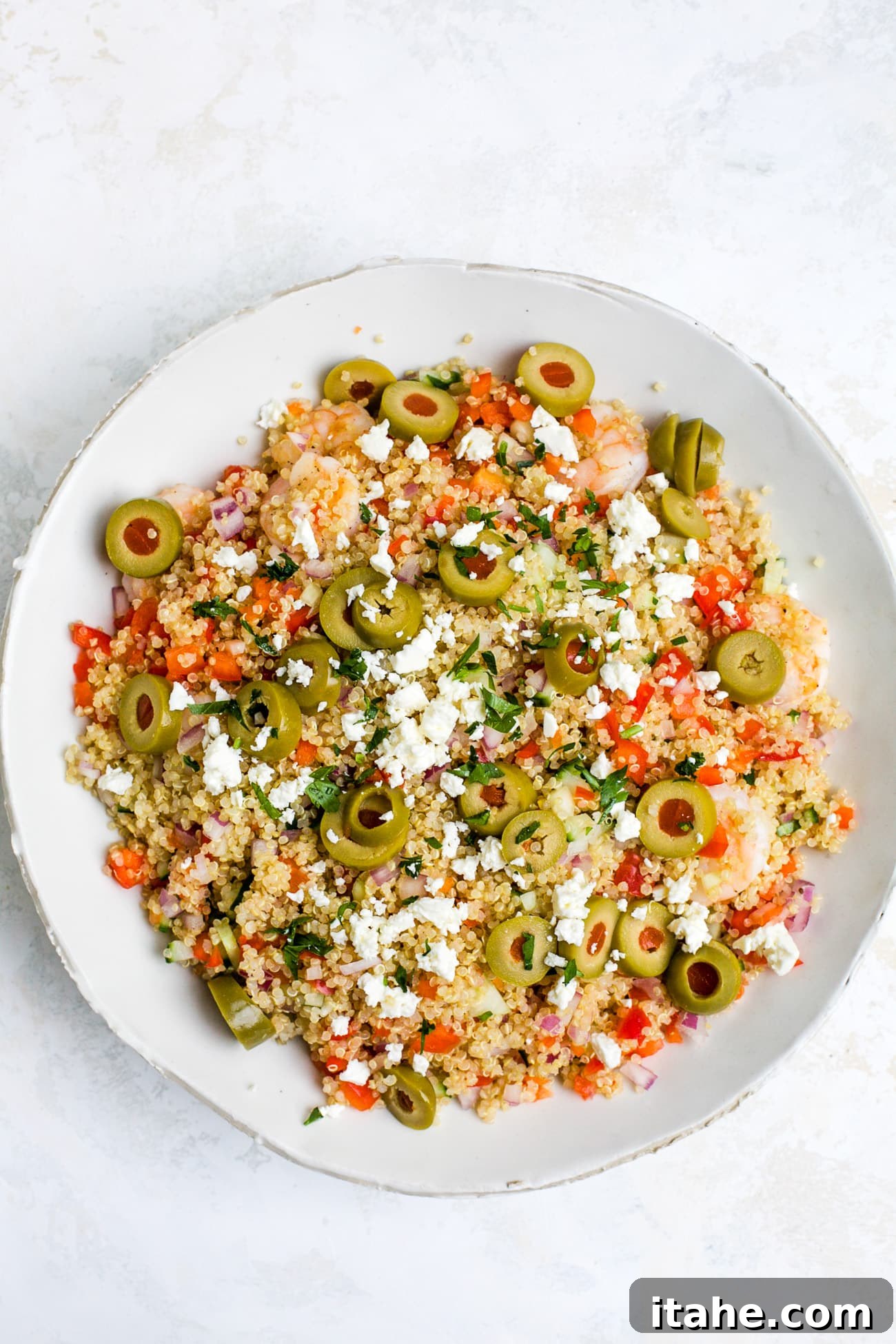 Overhead view of shrimp quinoa salad in a white bowl.