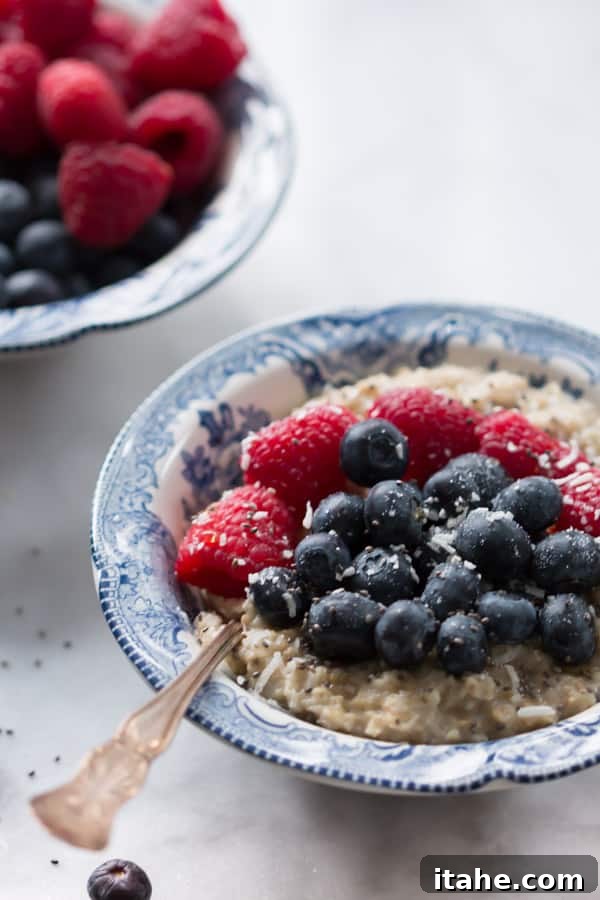 Delicious Coconut Berries Oatmeal with fresh blueberries and raspberries in a white bowl, perfect for a healthy breakfast.