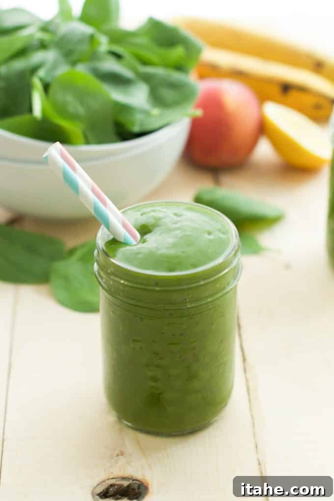 Tropical Mango Green Blend 5 Close-up of a refreshing Peach Green Smoothie in a mason jar with a straw