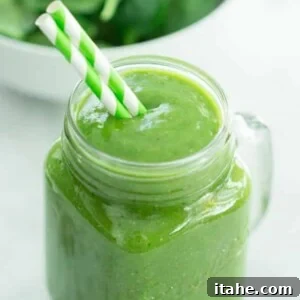 Tropical Mango Green Blend 2 Green Mango Smoothie served in a clear glass jar with a straw