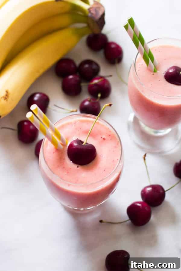 Tropical Mango Green Blend 4 Overhead photo of two glasses of bright red cherry pineapple smoothies, ready to drink.
